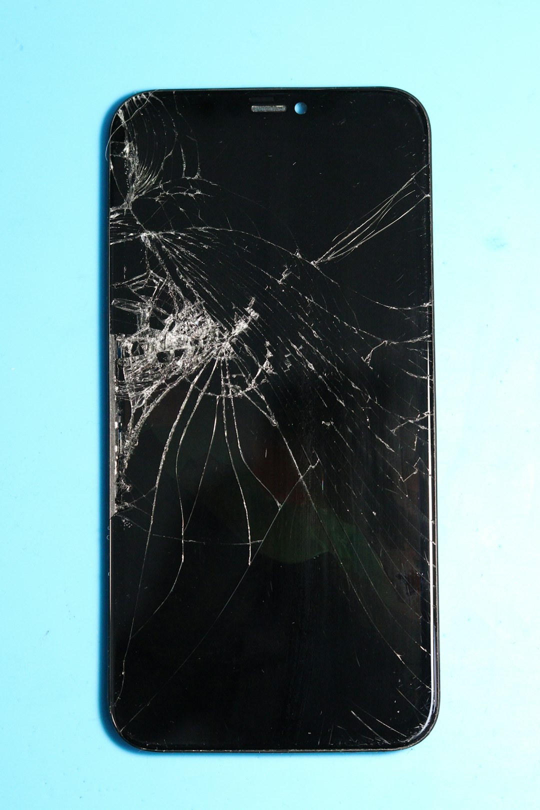 broken-smartphone-screen-on-a-blue-surface-pkw0nav8ubk